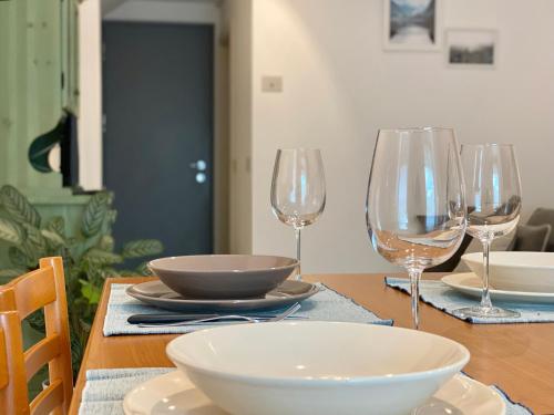 a table with bowls and wine glasses on it at Piano terra con esterno privato vicino a Pinzolo in Carisolo