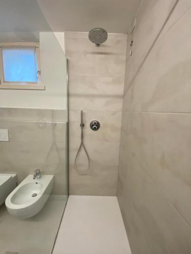 a white bathroom with a shower and a sink at Piano terra con esterno privato vicino a Pinzolo in Carisolo