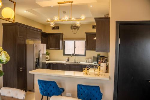 une cuisine avec des armoires marron et des chaises bleues dans l'établissement The Luxe Escape Luxury Suite, à Stanmore Grove