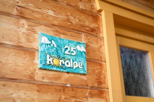 a sign on the side of a building at Feriendorf Koralpe Chalet Alpenperle in Hartelsberg