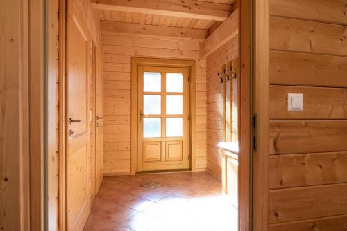 a hallway with a door in a log cabin at Feriendorf Koralpe Chalet Alpenperle in Hartelsberg