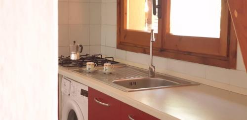 een keuken met een spoelbak en een wasmachine bij Villa Agavi 61 in Costa Rei