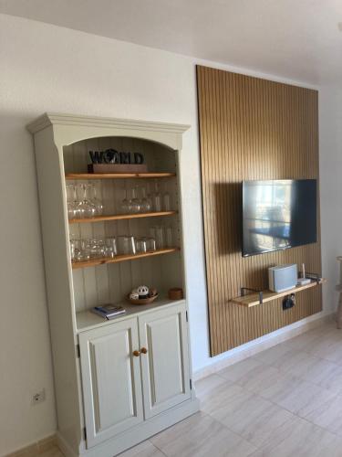 a room with a white cabinet with glasses in it at Kustdroom in Villaricos