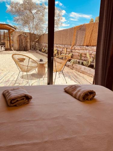 a bed in a room with a view of a desert at Domaine FINCA LESSYA, Lodge insolite & SPA in Mauguio