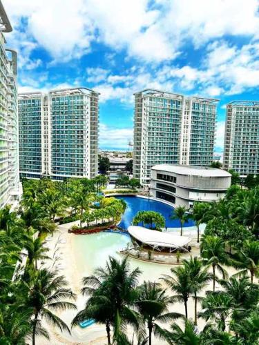 a resort with a pool and palm trees and buildings at Holiday Escape Philippines in Manila