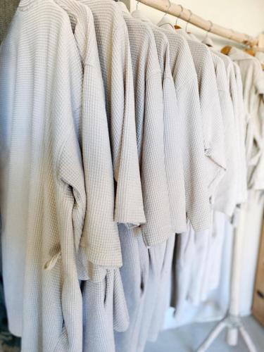 a row of white shirts hanging on a rack at Domaine FINCA LESSYA, Lodge insolite & SPA in Mauguio