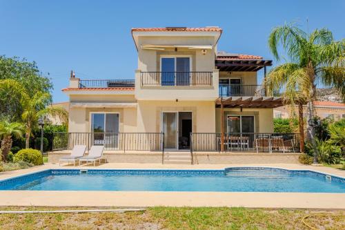 a villa with a swimming pool in front of a house at H&O Villa Arizona Gold Residence in Peyia