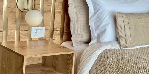 a bedroom with a bed and a nightstand with a light switch at Chalés Quinta da Boa Vista in São Bento do Sapucaí