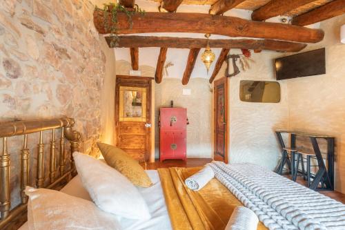 a bedroom with a bed in a room with a stone wall at Druida in Olba