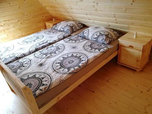 a bed in a cabin with a wooden floor at Chatka vo Vysokých Tatrách in Tatranska Strba