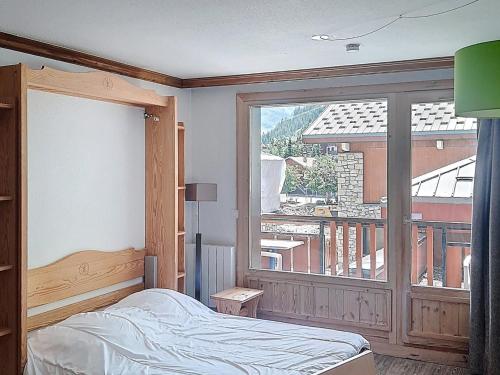 une chambre avec un lit et une grande fenêtre dans l'établissement Studio Confortable 27m² - Centre Val d'Isère avec Balcon Sud, 2/3 Pers., Cuisine Équipée - FR-1-518-145, à Val dʼIsère