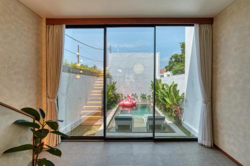 a room with a large glass door with a view of a patio at U Villas II - Uluwatu in Uluwatu