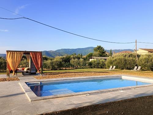 a swimming pool in a yard with a tent at CORTONA Piscina e Paradiso Verde Adults Only in Cortona
