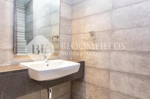 a bathroom with a white sink and a mirror at Bloomfields Stylish 2br in Ajwan Soul Beach Access in Abu Dhabi