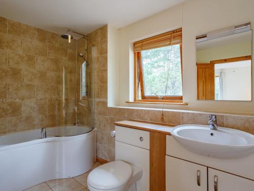 ein Badezimmer mit Badewanne und Waschbecken in der Unterkunft 4 Bed in Fort William 78875 in Torcastle