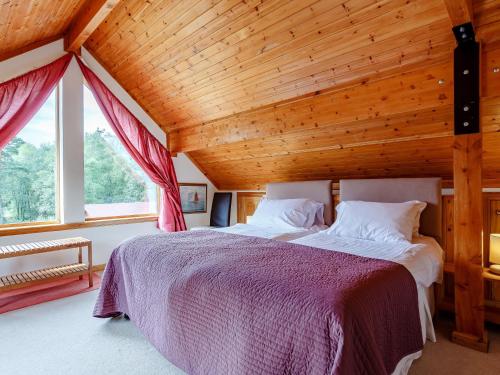 ein Schlafzimmer mit einem großen Bett und einer Holzdecke in der Unterkunft 4 Bed in Fort William 78875 in Torcastle