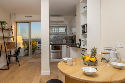 - une cuisine avec une table en bois et un bol de fruits dans l'établissement appartement 1ère ligne avec accès plage, à Palavas-les-Flots