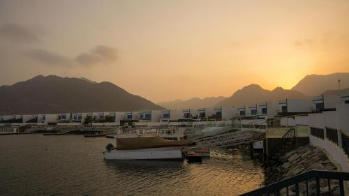 a group of buildings and boats in a body of water at Marina & Mountain View 4BR Private Villa in Fujairah