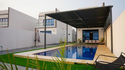 a house with a swimming pool in a yard at Marina & Mountain View 4BR Private Villa in Fujairah