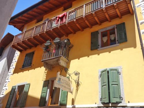 a yellow building with a balcony and a sign on it at Appartamento Casaliva in Pieve Di Ledro