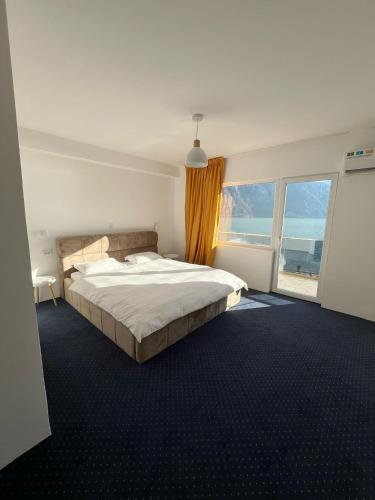 a bedroom with a large bed and a large window at Anacor in Dubova