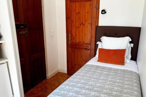 a bedroom with a bed with a orange pillow on it at Hotel Casa Bougainvillea in Sóller