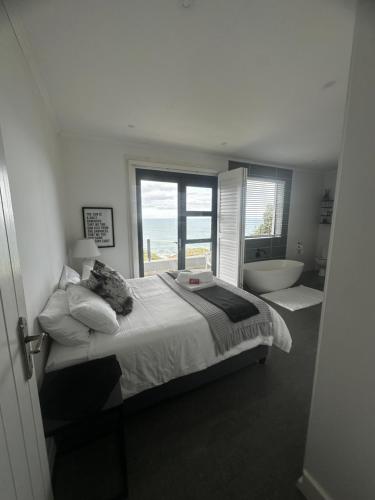 a bedroom with a bed and a tub and a window at Tranquillo in Mossel Bay