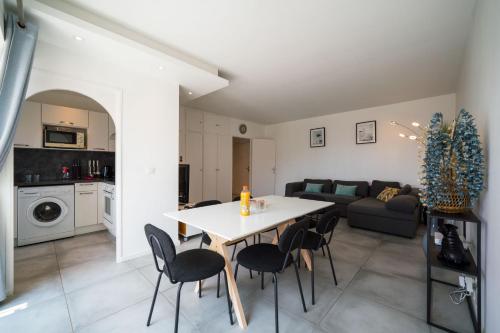 une cuisine et un salon avec une table et des chaises dans l'établissement Évasion Pointe Croisette, vue mer, plage à une minute, à Cannes