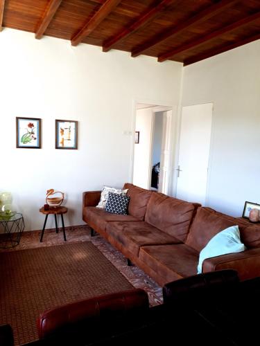 a living room with a brown leather couch at Casa Natura Galicia in Santa María La Mayor del Rosario