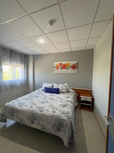 1 dormitorio con cama grande y almohada azul en Apartment Autovia Bormujos, en Bormujos