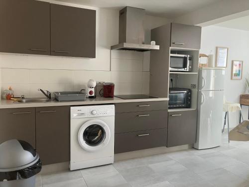 une cuisine avec un lave-linge et un réfrigérateur dans l'établissement Maisonette proche mer, à Saint-André-des-Eaux