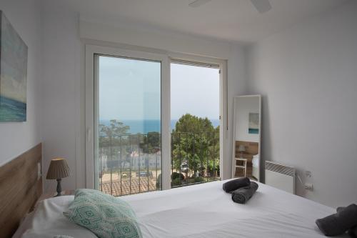 a bedroom with a bed and a large window at Ka Mahina a Calella de Palafrugell in Calella de Palafrugell