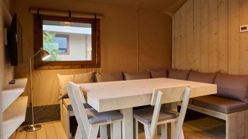 einen Tisch und Stühle in einem Zimmer mit Sofa in der Unterkunft moderne Glampingzelte in Winterberg
