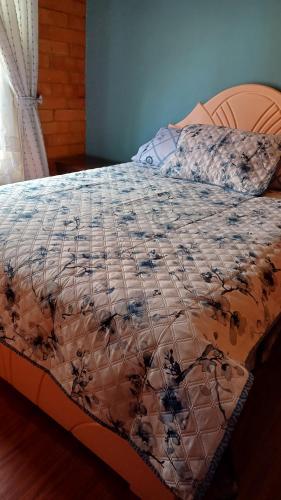 a bed with a quilt on top of it at Casa Paipa in Paipa