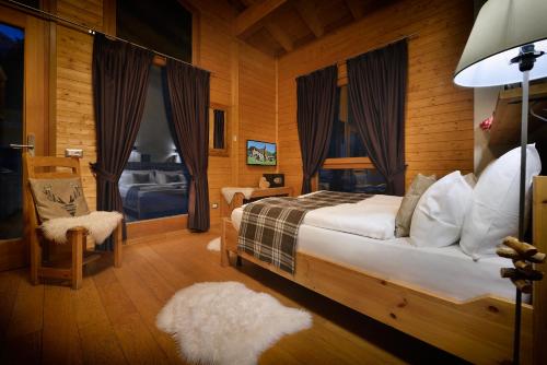a bedroom with a bed and a chair and a window at La Tresenda Hotel and Mountain Farm in Livigno