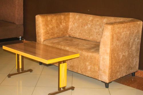 a brown couch with a wooden coffee table at Pacific Land Guesthouse in Burega
