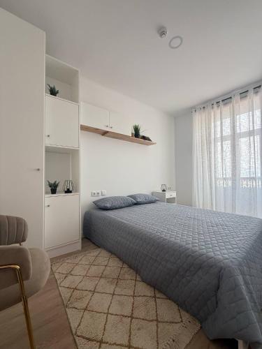 a white bedroom with a bed and a window at Cidade Mar in Horta