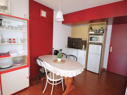 une petite cuisine avec une table et des chaises. dans l'établissement Appartement Rez-de-Jardin Bord de Mer, Terrasse 30m², 5 Pers, Port Camargue - FR-1-307-228, au Grau-du-Roi
