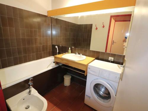 une salle de bain avec une machine à laver et un lavabo dans l'établissement Appartement Rez-de-Jardin Bord de Mer, Terrasse 30m², 5 Pers, Port Camargue - FR-1-307-228, au Grau-du-Roi