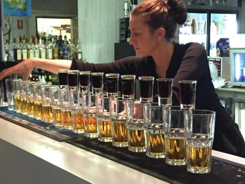 a woman behind a bar with a row of wine glasses at Siesta Villa in Jindabyne