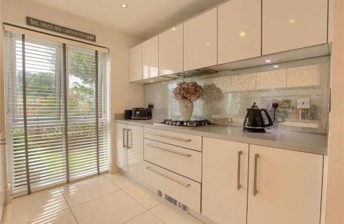 Una cocina con gabinetes blancos y una ventana grande. en 4 Bed modern luxury home, en Middlesbrough