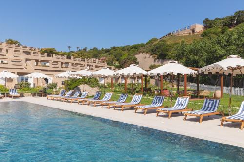 a row of lounge chairs next to a swimming pool at Mangia's Sardinia Resort - NEW OPENING in Santa Teresa Gallura