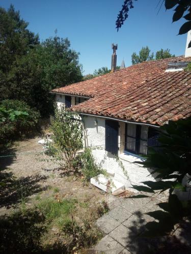 an old white house with a red roof at Gite Du Rocher in Mareuil-sur-Lay