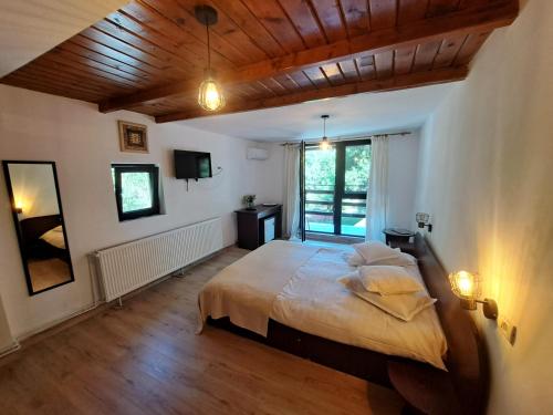 a bedroom with a large bed with a wooden ceiling at Moara Viselor in Vaideeni