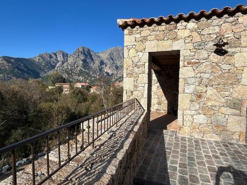 a stone building with a gate and a balcony at Casa Scaledda in Bocognano