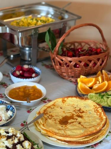 a table topped with plates of food and a basket of fruit at Agroturystyka Lucyna Babińska in Wünschelburg