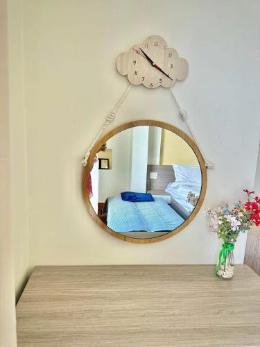 a mirror with a clock hanging on a wall at Khách sạn Sinh Hiền in Liên Trì (4)