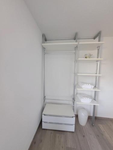 a white closet with white shelves and a floor at Welcome House in Spa