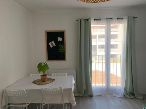 La Celle-sous-GouzonにあるStudio vert idéalement situé gare cœur de ville et accès direct bus futuroscopeの白いダイニングルーム(テーブル、窓付)