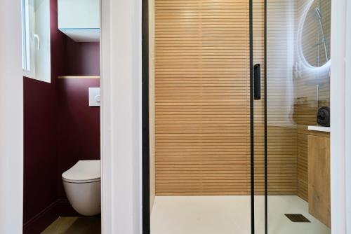 a bathroom with a toilet and a glass shower at Le Cinema - Les Demeures d'Adrien in Armentières